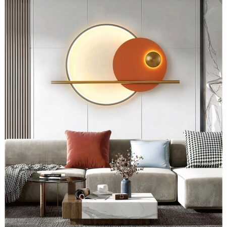 in een woonkamer met witte, grijze en oranje tinten zien we een grote ronde oranje wandlamp in eigentijdse stijl