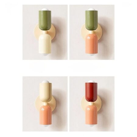een lichtgrijze muur toont 4 wandlampen in scandinavische stijl in verschillende kleuren: wit, groen, roze en rood