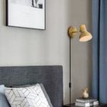 Een bedrade wandlamp in industriële stijl in goud als hoofdeinde