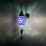 Een druppelvormige wandlamp in oosterse stijl met mozaïeken bevestigd aan een muur