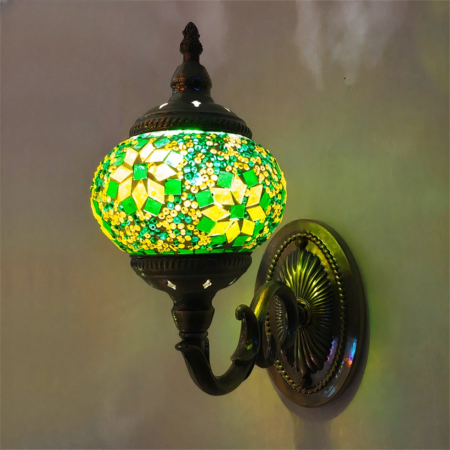 Een groene en gele oriëntaalse bloemenwandlamp bevestigd aan een muur