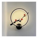 op een lichtgrijze muur, een ronde metalen wandlamp in Japanse stijl in zwart