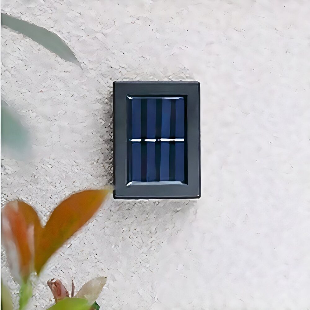 een buitenwandlamp op zonne-energie wordt gezien op een buitenmuur, ze is uitgeschakeld