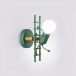 Smeedijzeren wandlamp met een klimladder, verlicht en in de groene versie, opgehangen aan de muur.